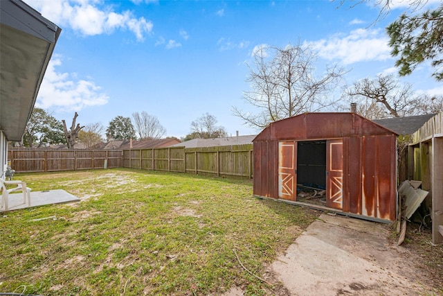 view of yard with an outbuilding, a shed, and a fenced backyard