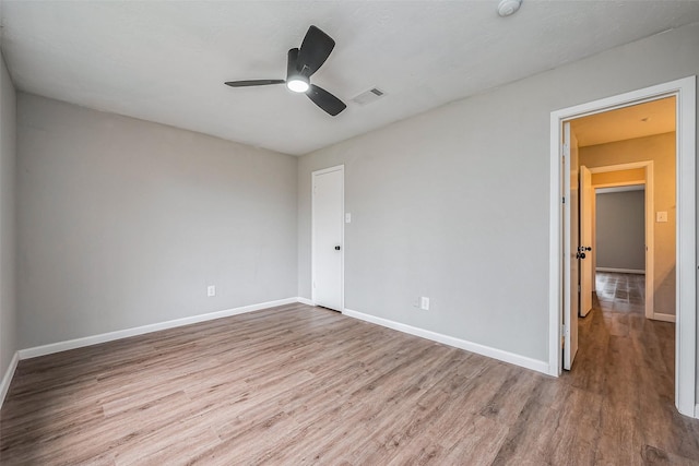 unfurnished bedroom featuring visible vents, ceiling fan, baseboards, and wood finished floors