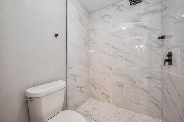 bathroom with tiled shower and toilet