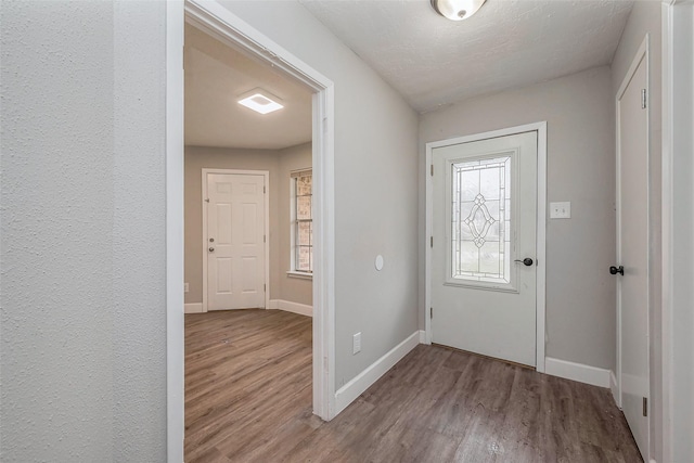 foyer entrance featuring baseboards and wood finished floors