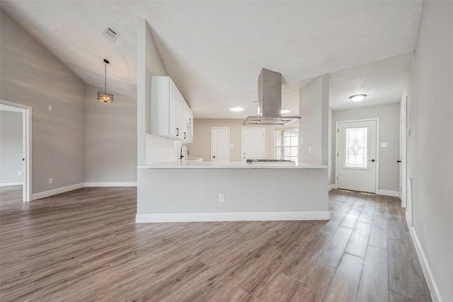 kitchen featuring light wood finished floors, visible vents, white cabinetry, and extractor fan