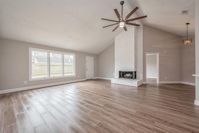 unfurnished living room featuring wood finished floors, a ceiling fan, visible vents, baseboards, and a fireplace