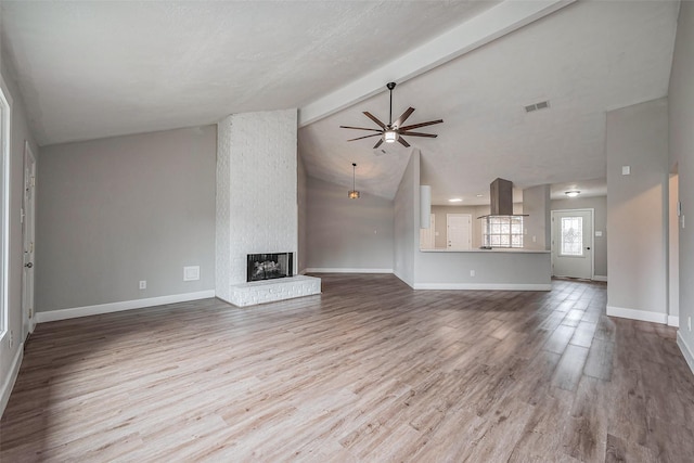 unfurnished living room featuring visible vents, baseboards, beamed ceiling, and wood finished floors