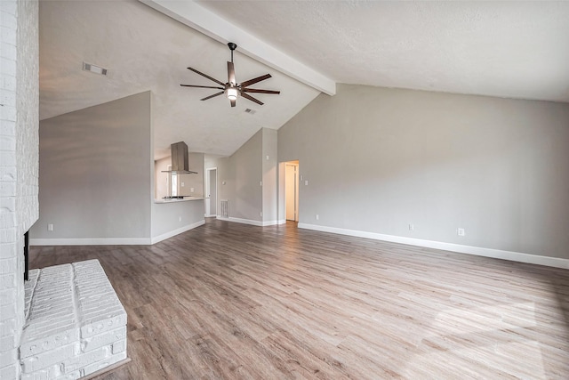 unfurnished living room featuring beamed ceiling, visible vents, wood finished floors, baseboards, and ceiling fan