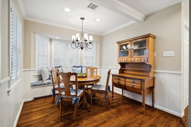 dining room featuring visible vents, crown molding, wainscoting, an inviting chandelier, and dark wood-style flooring