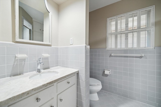 bathroom featuring a shower with door, tile patterned flooring, toilet, wainscoting, and vanity