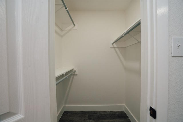 walk in closet with dark wood-type flooring