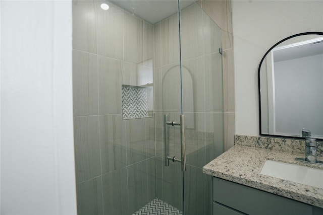 bathroom featuring a shower stall and vanity