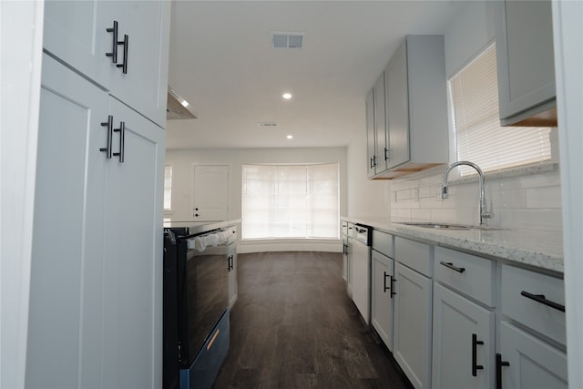 kitchen featuring visible vents, a sink, backsplash, dark wood-style floors, and electric range oven