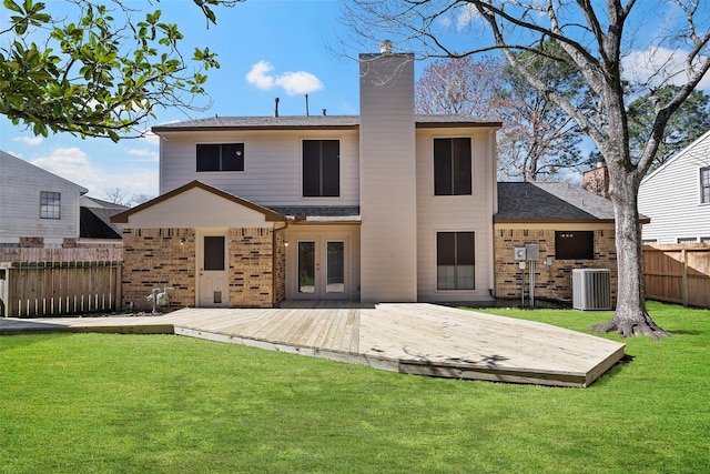 back of property featuring french doors, a lawn, a wooden deck, and fence