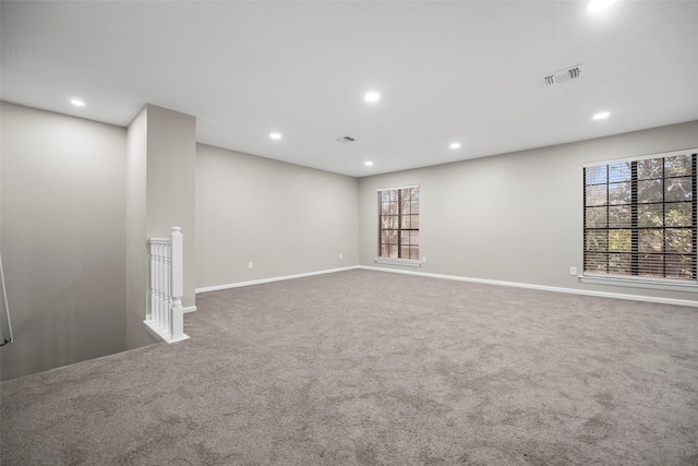 spare room with carpet flooring, recessed lighting, visible vents, and baseboards