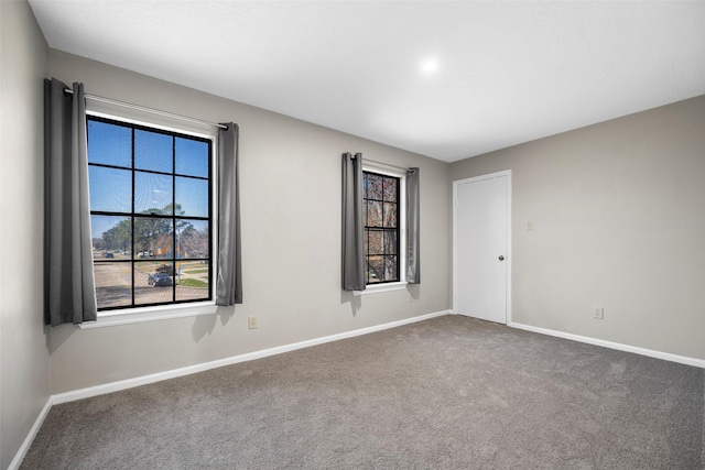 carpeted spare room featuring baseboards