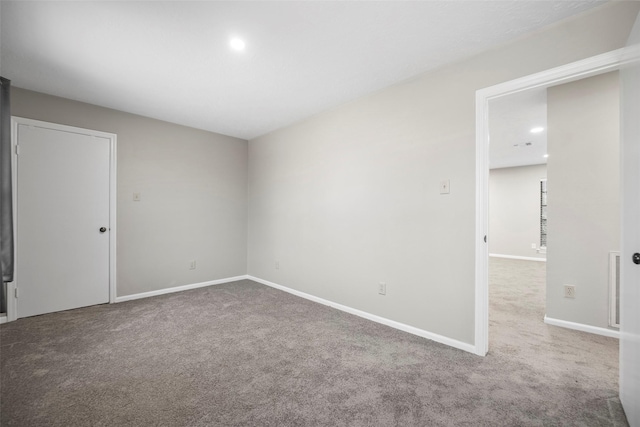 carpeted empty room with visible vents and baseboards