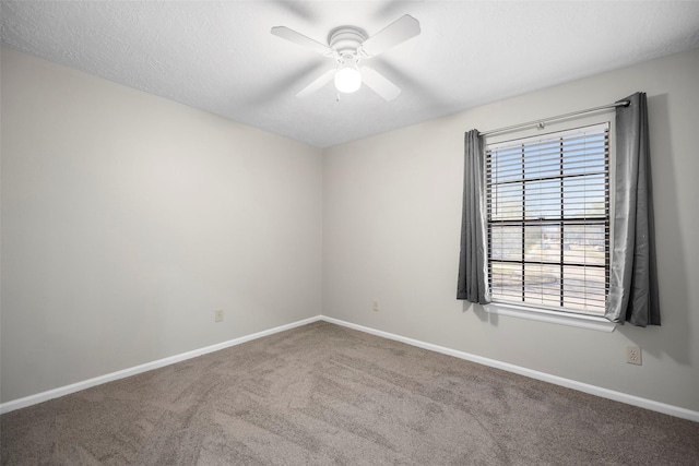 carpeted empty room featuring baseboards, a textured ceiling, and a ceiling fan