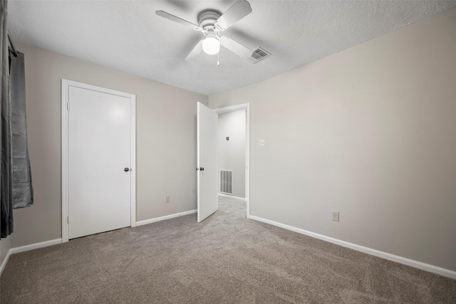 unfurnished bedroom with visible vents, a textured ceiling, baseboards, and carpet floors