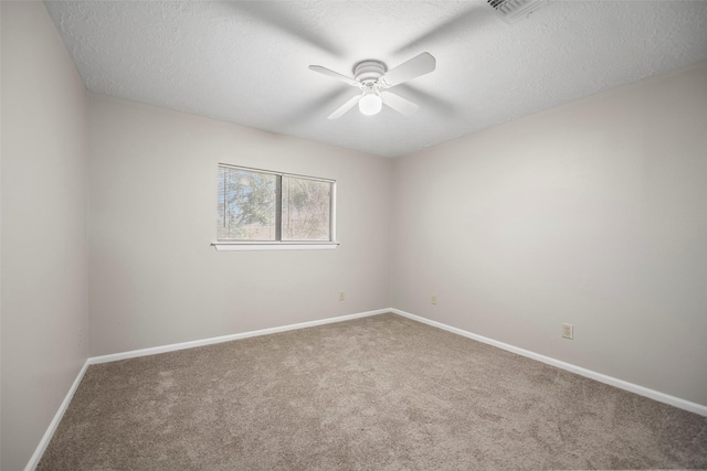 carpeted empty room with visible vents, baseboards, a textured ceiling, and ceiling fan