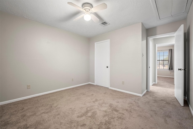 unfurnished bedroom featuring attic access, baseboards, visible vents, and carpet floors