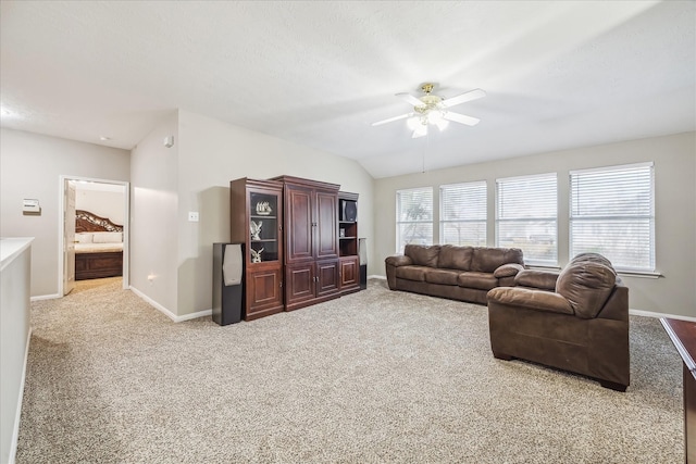 carpeted living area with baseboards, lofted ceiling, and ceiling fan