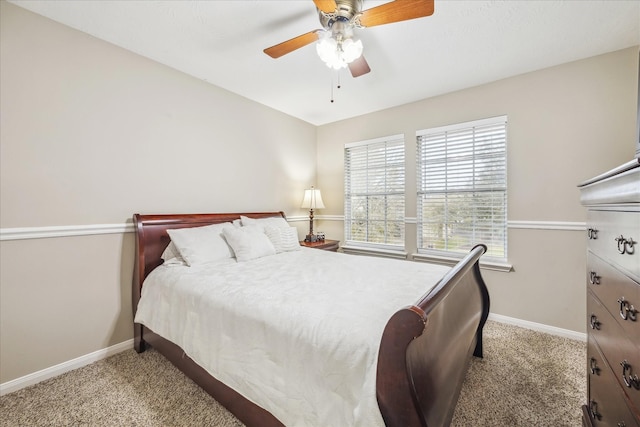 bedroom with a ceiling fan, light colored carpet, and baseboards