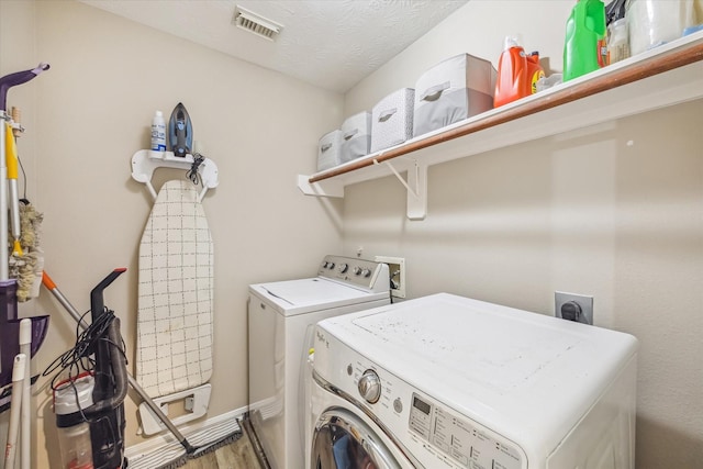 laundry room with visible vents, a textured ceiling, independent washer and dryer, and laundry area