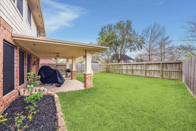 view of yard featuring a patio, a ceiling fan, and a fenced backyard