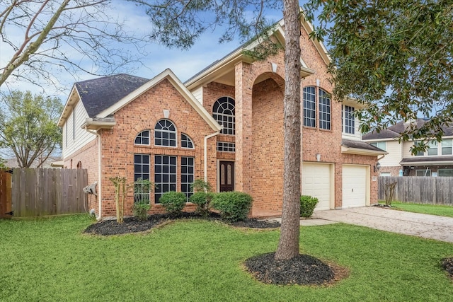 traditional-style home with a front yard, fence, concrete driveway, a garage, and brick siding