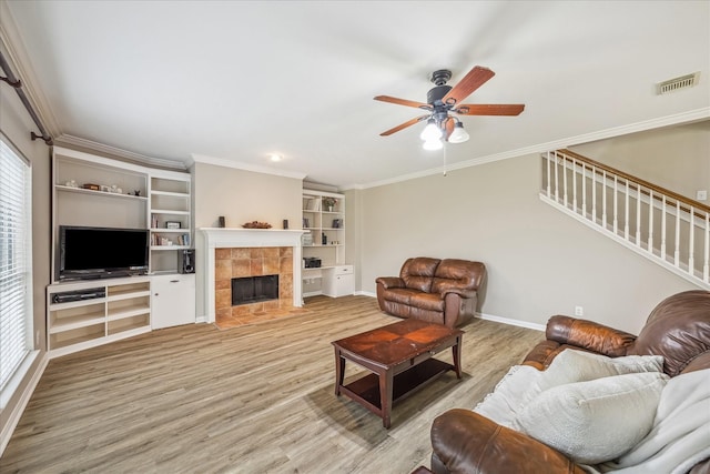 living area with visible vents, light wood-style flooring, stairway, and a ceiling fan