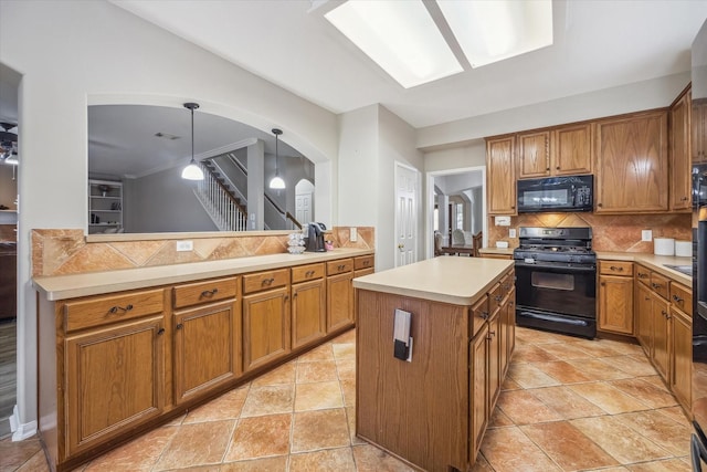 kitchen with tasteful backsplash, a kitchen island, arched walkways, brown cabinetry, and black appliances