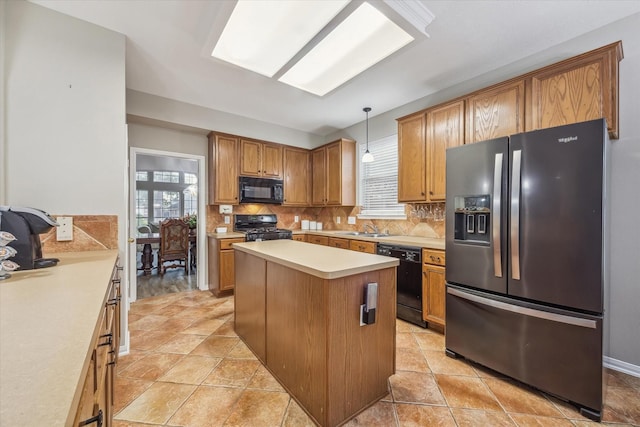 kitchen featuring a sink, tasteful backsplash, black appliances, and light countertops