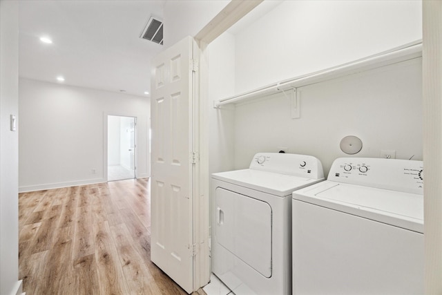 clothes washing area featuring visible vents, light wood-style flooring, washer and dryer, recessed lighting, and laundry area