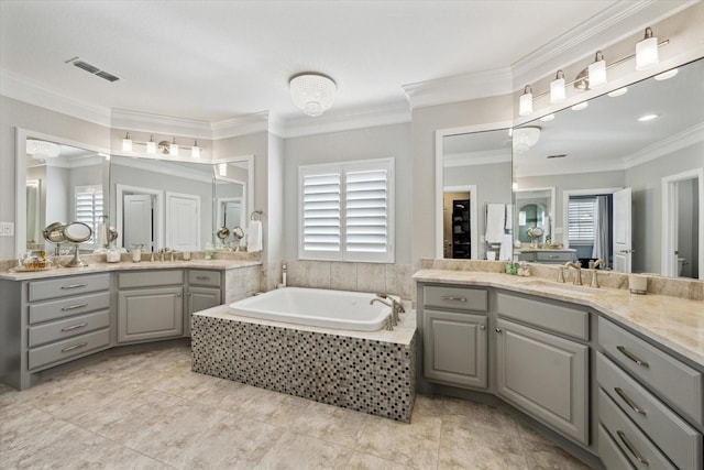 bathroom featuring visible vents, two vanities, a sink, crown molding, and a bath