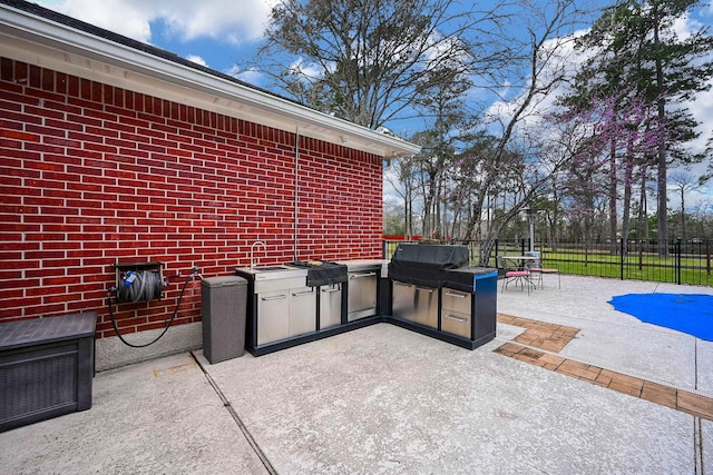 view of patio with area for grilling, outdoor dining space, a grill, and fence