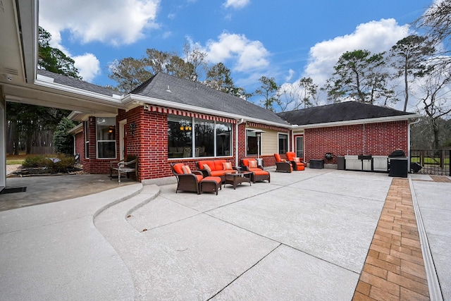 back of property with brick siding, outdoor lounge area, and a patio area