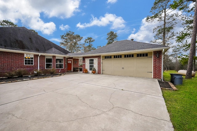 view of front facade with driveway, brick siding, an attached garage, and a front lawn