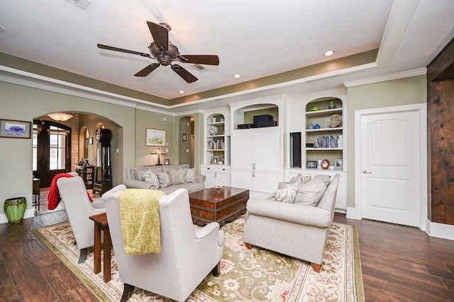 living area featuring a tray ceiling, arched walkways, ceiling fan, and dark wood-style flooring