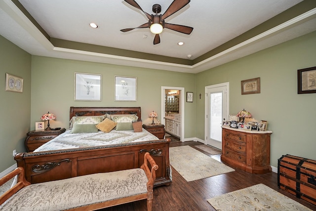 bedroom with dark wood finished floors, a tray ceiling, recessed lighting, and baseboards