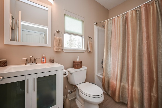 bathroom featuring vanity, toilet, shower / bathtub combination with curtain, and baseboards