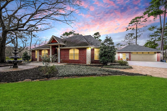 view of front of home with concrete driveway, a garage, a lawn, and brick siding