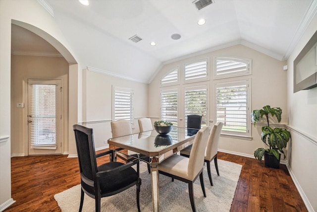 dining space with arched walkways, visible vents, dark wood-style flooring, and vaulted ceiling