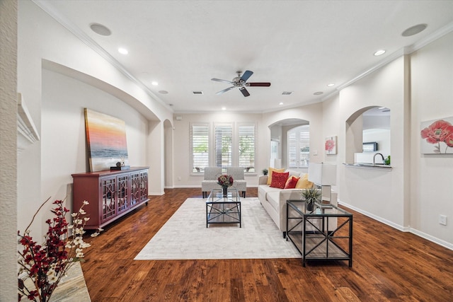 living room with ornamental molding, baseboards, a ceiling fan, and wood finished floors