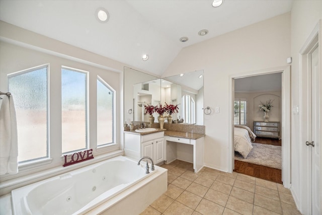 full bathroom featuring tile patterned floors, ensuite bathroom, a jetted tub, vanity, and vaulted ceiling