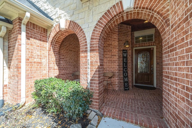 view of exterior entry featuring brick siding