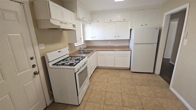 kitchen with under cabinet range hood, light tile patterned floors, white cabinets, white appliances, and a sink