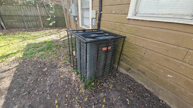 exterior details featuring central air condition unit, electric meter, and fence