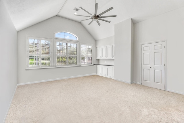 empty room featuring light colored carpet, baseboards, and ceiling fan