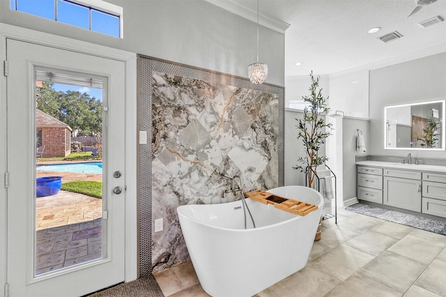 full bathroom featuring a freestanding tub, visible vents, tile walls, and vanity