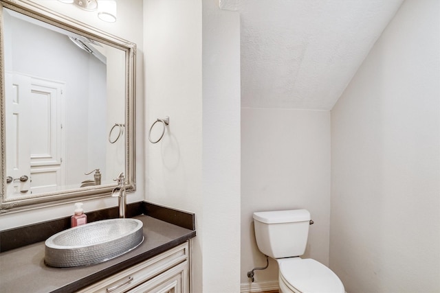 bathroom featuring vanity, toilet, and a textured ceiling