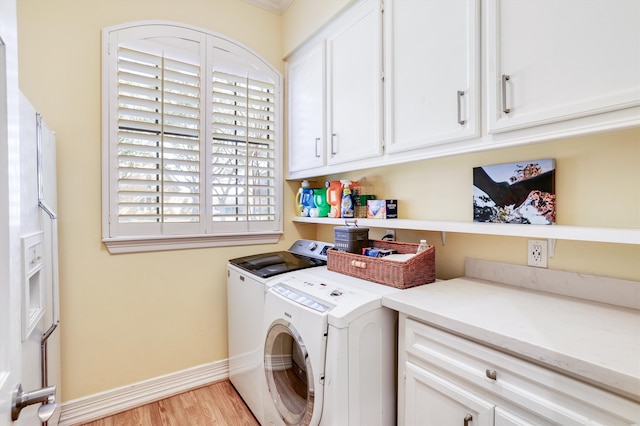 laundry room with washer and dryer, baseboards, cabinet space, and light wood finished floors