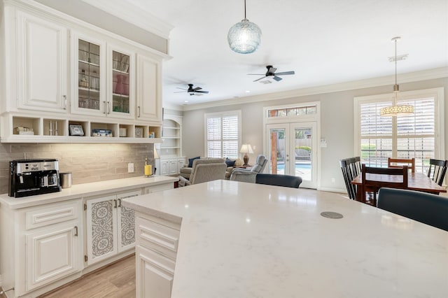 kitchen featuring decorative light fixtures, visible vents, a ceiling fan, and crown molding