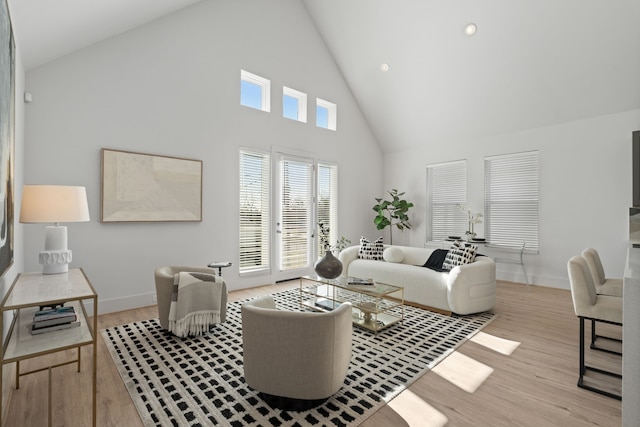 living room with recessed lighting, baseboards, high vaulted ceiling, and light wood finished floors